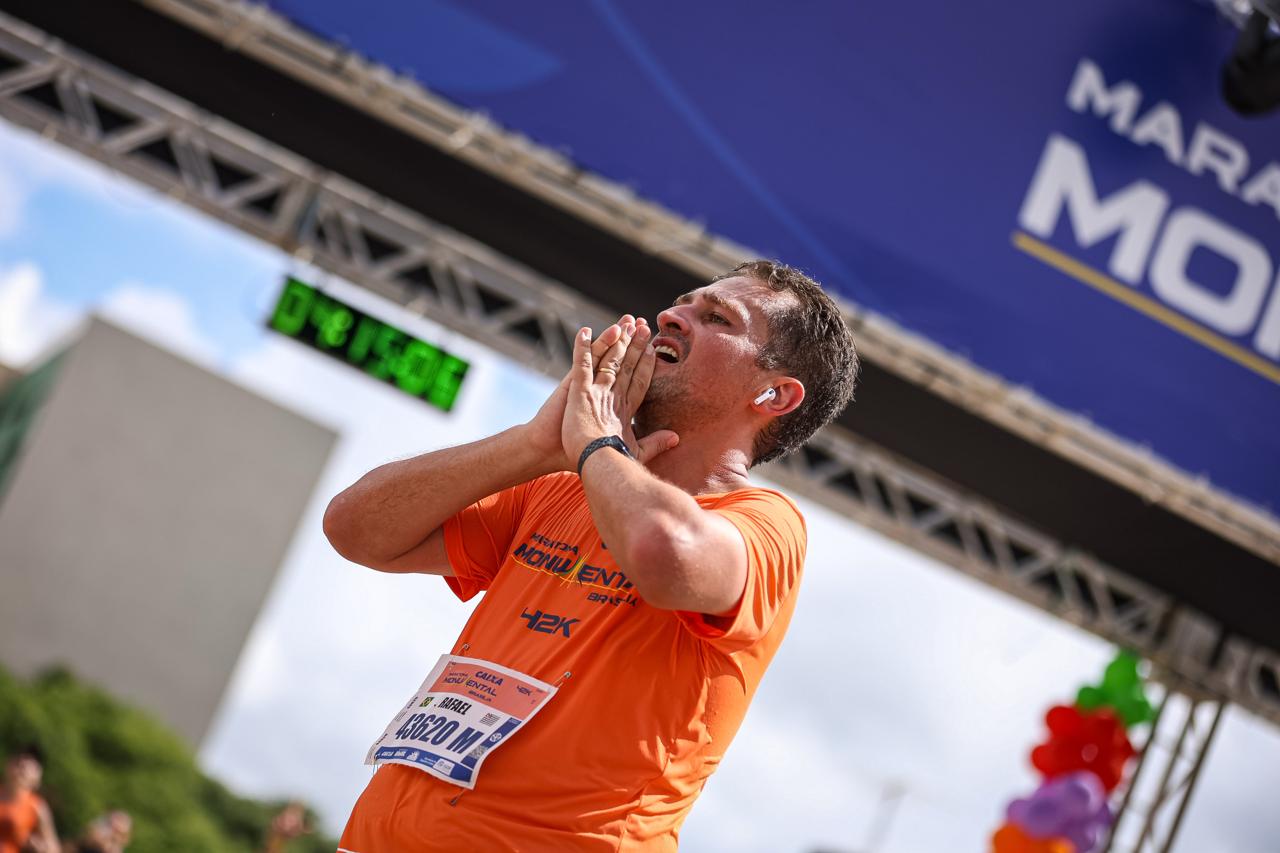 Rafael Franco correndo uma maratona, usando camiseta laranja, próximo à linha de chegada